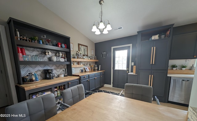 dining space with vaulted ceiling, light hardwood / wood-style floors, and a chandelier