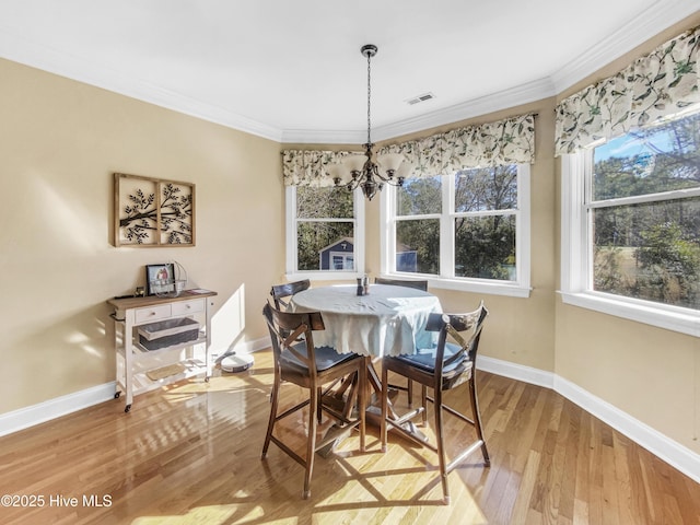 dining room featuring hardwood / wood-style flooring, crown molding, and an inviting chandelier