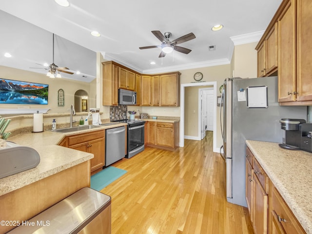 kitchen featuring sink, light hardwood / wood-style flooring, ornamental molding, ceiling fan, and stainless steel appliances