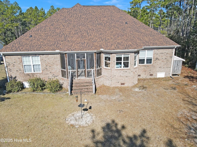 rear view of house with a lawn and a sunroom