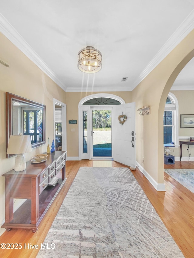 foyer with crown molding and hardwood / wood-style floors