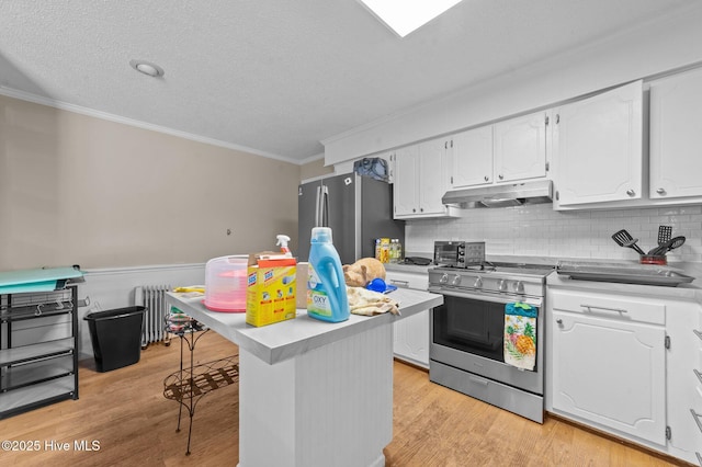 kitchen featuring white cabinetry, a kitchen bar, decorative backsplash, stainless steel appliances, and a textured ceiling