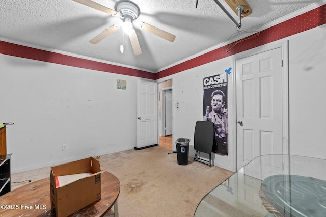 misc room featuring ceiling fan, ornamental molding, light colored carpet, and a textured ceiling