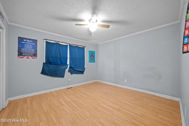 empty room with ceiling fan, wood-type flooring, ornamental molding, and a textured ceiling