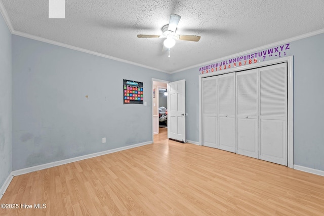 unfurnished bedroom featuring a textured ceiling, ornamental molding, light hardwood / wood-style floors, and ceiling fan