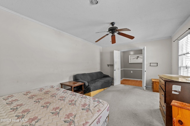 carpeted bedroom featuring ornamental molding, a textured ceiling, and ceiling fan