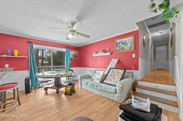 living room with crown molding, hardwood / wood-style floors, a textured ceiling, and ceiling fan