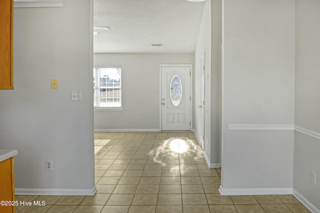 entryway featuring a textured ceiling and light tile patterned floors