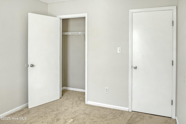 unfurnished bedroom featuring a closet and light carpet