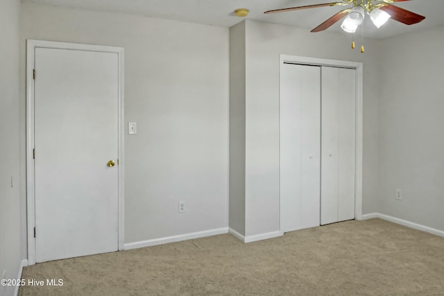 unfurnished bedroom featuring ceiling fan, light colored carpet, and a closet