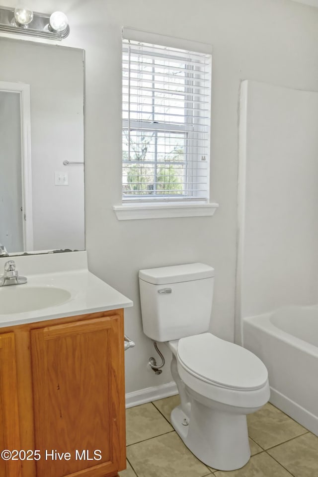 bathroom with plenty of natural light, tile patterned floors, vanity, and toilet