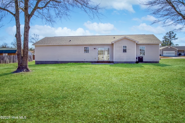 rear view of property with a garage and a lawn