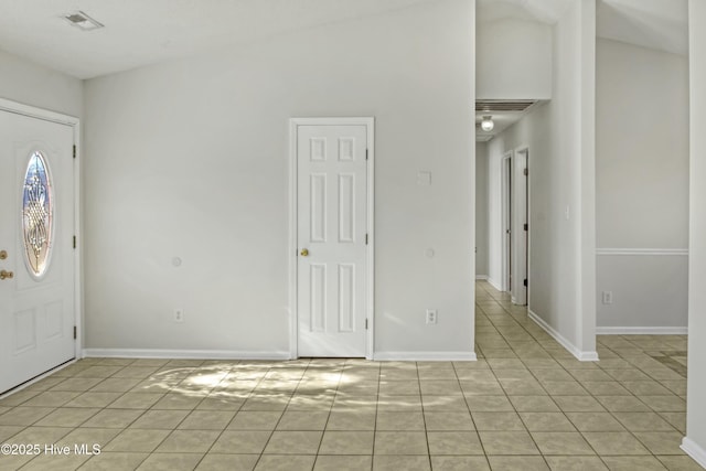 entrance foyer featuring lofted ceiling and light tile patterned flooring