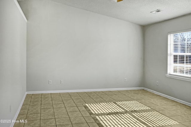 empty room with a textured ceiling and tile patterned floors