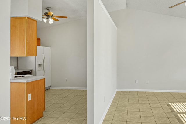 kitchen with ceiling fan, vaulted ceiling, light tile patterned flooring, and white fridge with ice dispenser