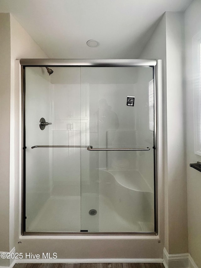 bathroom featuring a shower with door