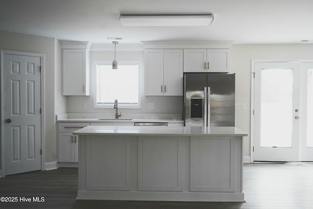 kitchen with stainless steel fridge with ice dispenser, a center island, and white cabinetry