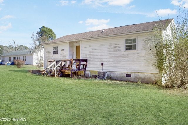 back of property featuring cooling unit and a lawn