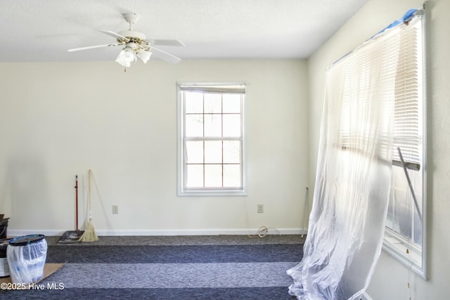 carpeted spare room featuring a textured ceiling and ceiling fan