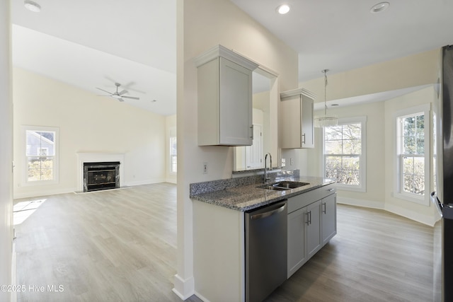 kitchen with sink, light hardwood / wood-style flooring, gray cabinets, dishwasher, and vaulted ceiling