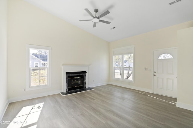 unfurnished living room with hardwood / wood-style flooring, plenty of natural light, and a high end fireplace