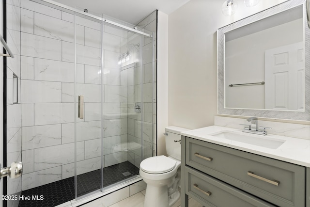 bathroom featuring vanity, tile patterned flooring, a shower with shower door, and toilet