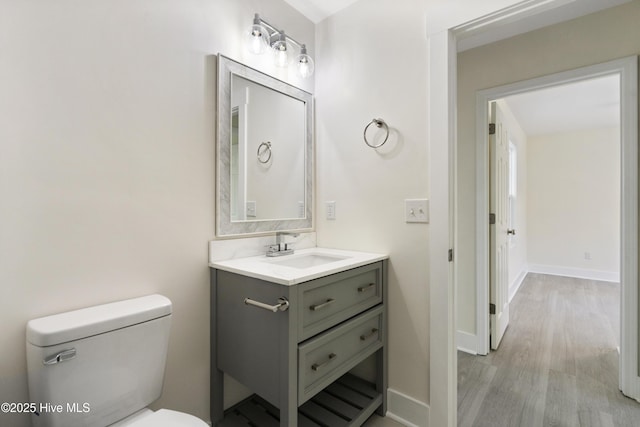 bathroom featuring vanity, toilet, and hardwood / wood-style floors