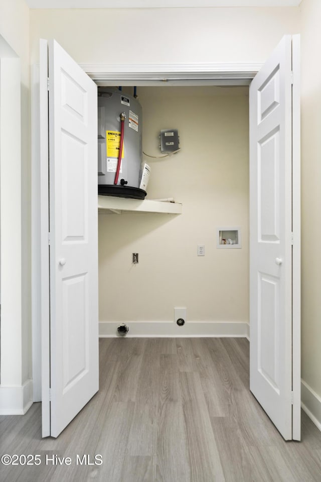 laundry room featuring water heater, washer hookup, and light wood-type flooring