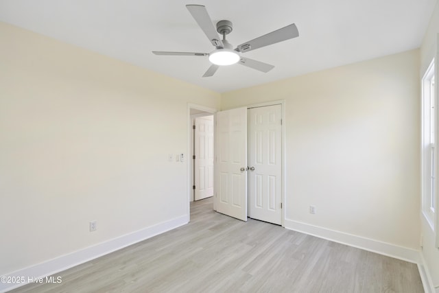 unfurnished bedroom featuring ceiling fan, light hardwood / wood-style floors, and a closet