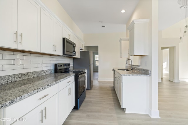 kitchen featuring white cabinetry, black electric range oven, light stone countertops, and sink