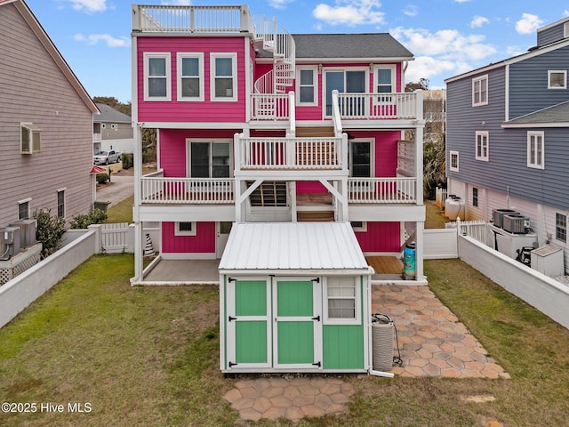 back of house with a storage shed, a patio, a balcony, and central air condition unit