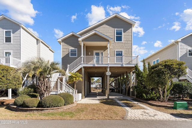 coastal inspired home with a carport, a porch, stairway, and driveway