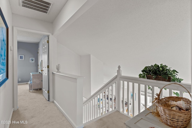 hall featuring light colored carpet