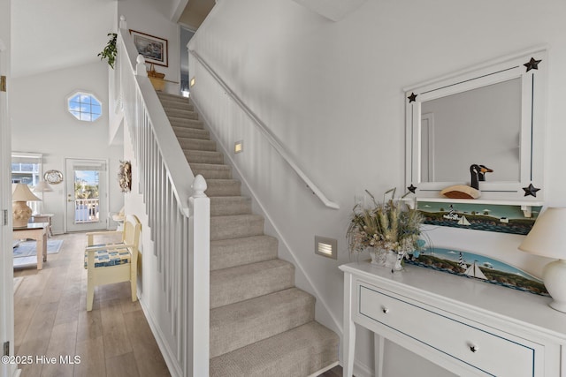 stairs featuring hardwood / wood-style flooring and a high ceiling