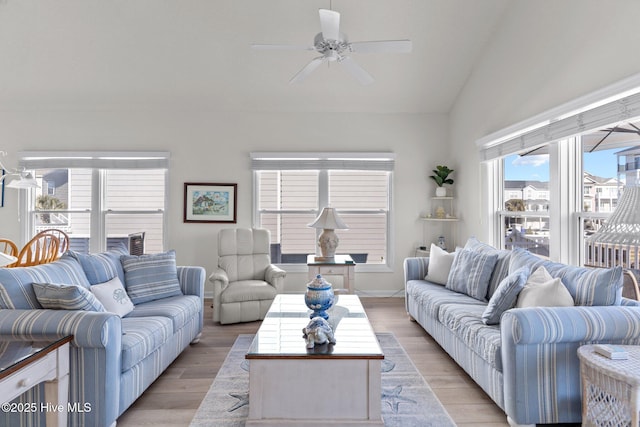 living room with ceiling fan, light wood-type flooring, and lofted ceiling