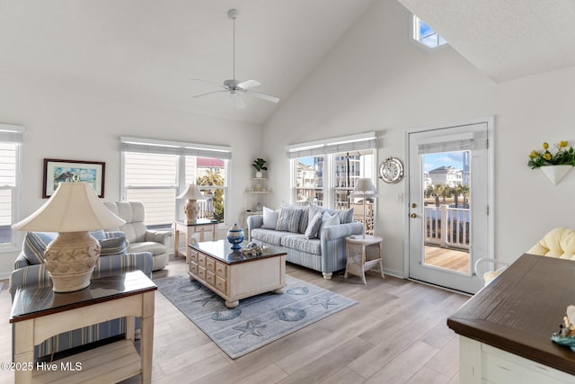 living room featuring high vaulted ceiling, a wealth of natural light, ceiling fan, and light wood-type flooring