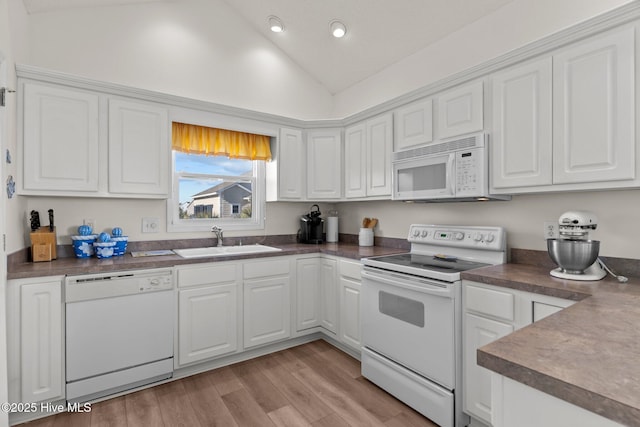 kitchen featuring light hardwood / wood-style flooring, sink, white cabinets, white appliances, and lofted ceiling