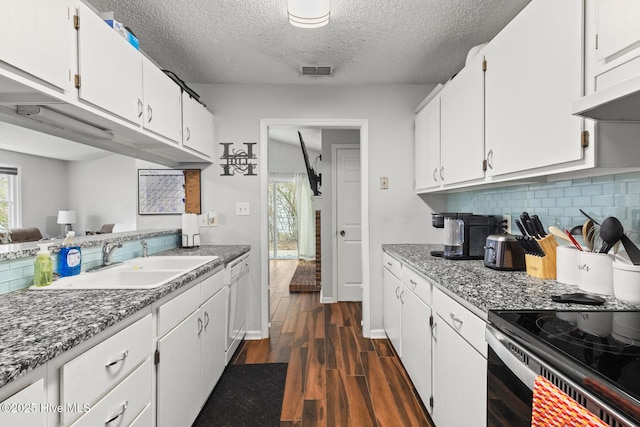 kitchen with dark wood-type flooring, a sink, visible vents, white cabinets, and dishwasher