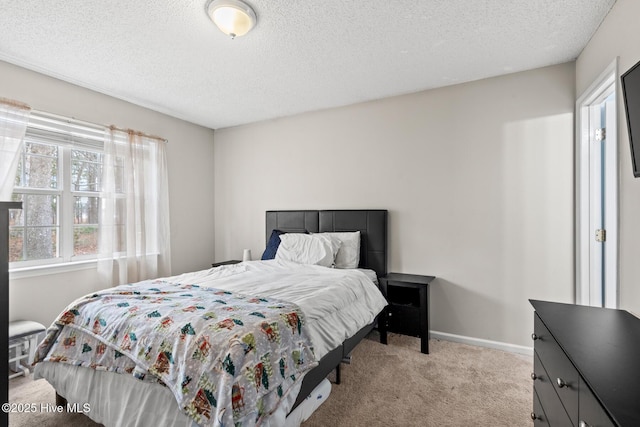 bedroom with baseboards, a textured ceiling, and light colored carpet