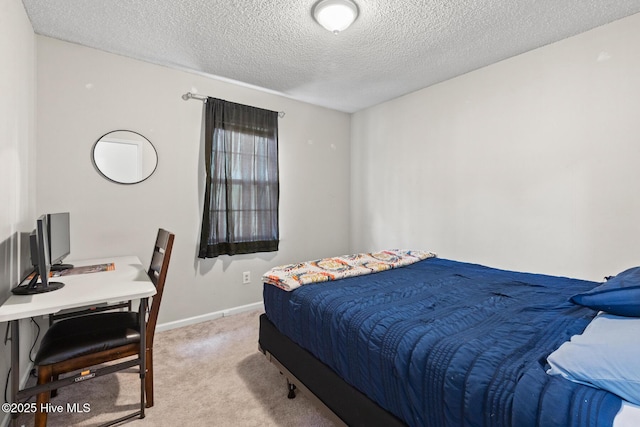 bedroom with light colored carpet and a textured ceiling