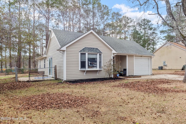 single story home featuring concrete driveway, roof with shingles, fence, and an attached garage