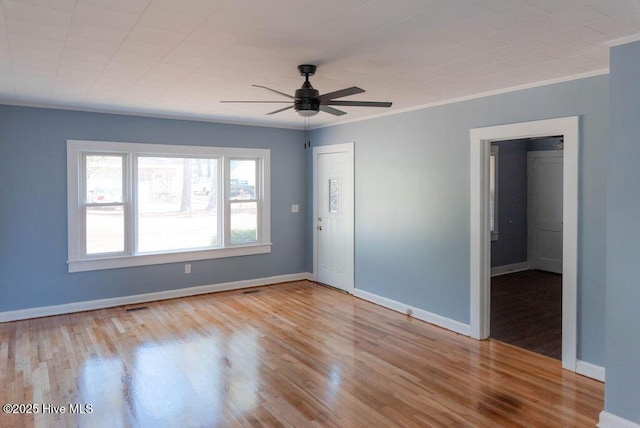 spare room with crown molding, light wood-type flooring, and ceiling fan