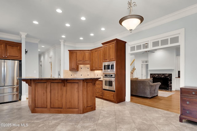 kitchen with a kitchen island, appliances with stainless steel finishes, a breakfast bar, dark stone countertops, and decorative backsplash