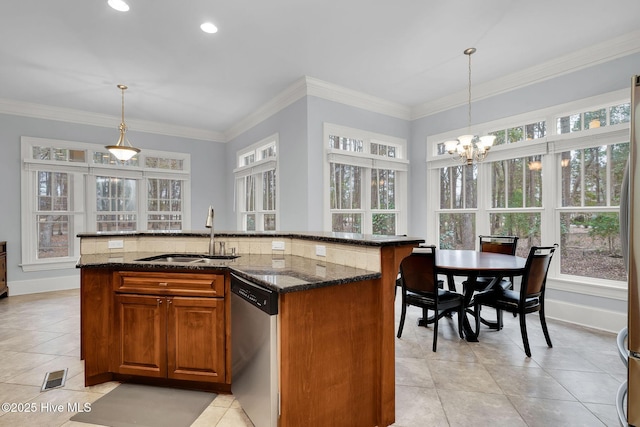 kitchen featuring pendant lighting, dishwasher, sink, and a center island with sink