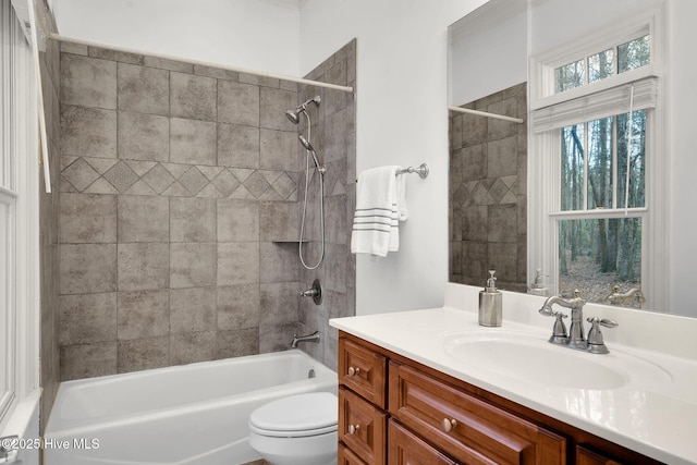 full bathroom featuring tiled shower / bath combo, vanity, and toilet