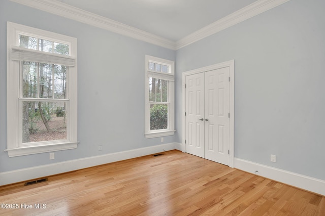 empty room with light hardwood / wood-style flooring and ornamental molding