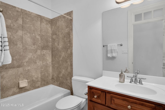 full bathroom featuring vanity, tiled shower / bath, and toilet