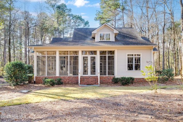 back of house featuring a lawn and a sunroom