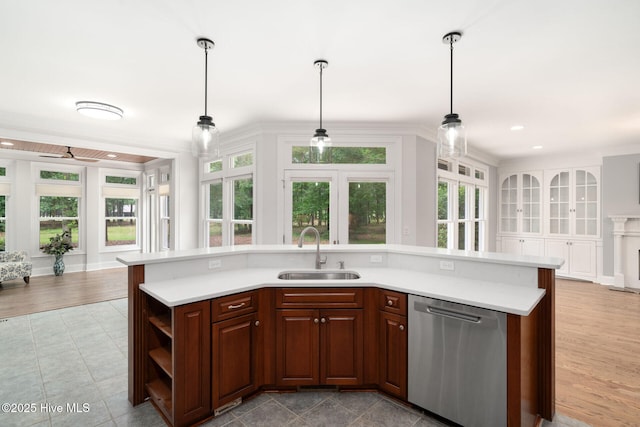 kitchen with sink, pendant lighting, dishwasher, and a center island with sink