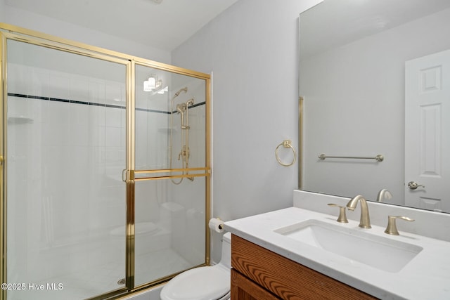 bathroom featuring vanity, toilet, and a shower with door